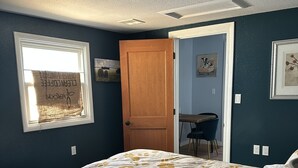 Une chambre à coucher avec un lit, une fenêtre, une porte et une chaise.