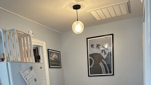 Une cuisine de taille réduite avec un réfrigérateur blanc, une table à manger en bois et deux chaises bleues.