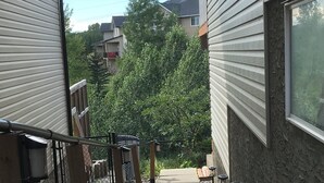A pathway leading to a building with a wooden railing and a metal handrail.