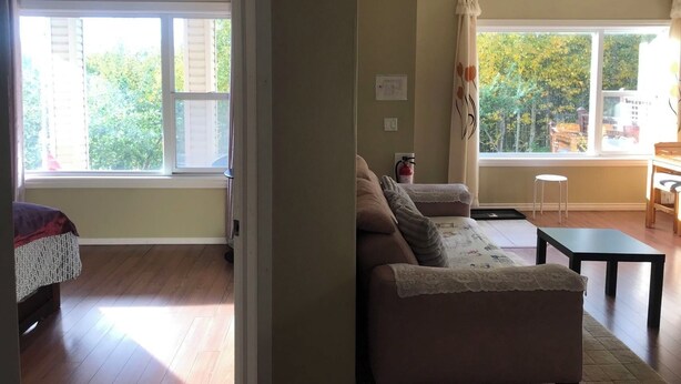 A living room with a sofa, a small table, and a window with curtains.