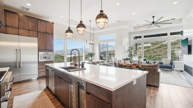 A spacious kitchen with a large island, stainless steel appliances, and pendant lighting.