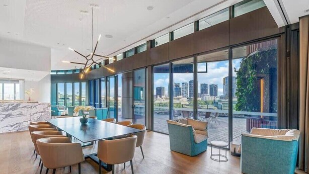 A modern conference room with a large table, comfortable seating, and large windows offering a city view. - CASSA ONE - Luxury Riverside Living in BNE CBD (Brisbane)