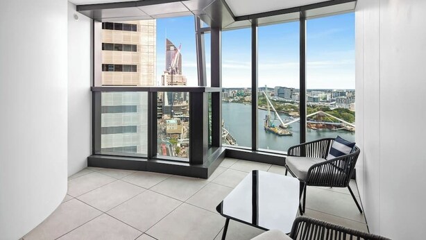 A modern balcony with a view of a cityscape and a river.