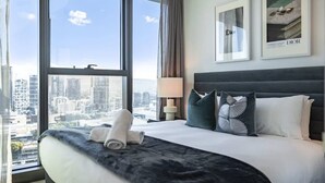 A hotel room with a large bed, a city view, and framed posters on the wall. - CASSA ONE - Heart of CBD, City Escape w/ Riverview (Brisbane City)
