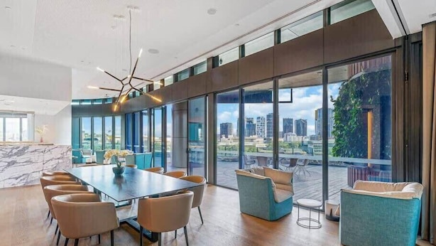 A modern conference room with a large table, comfortable seating, and large windows offering a city view. - CASSA ONE - Heart of CBD, City Escape w/ Riverview (Brisbane City)