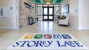 Um saguão de hotel com uma recepção, uma área de estar e uma placa com a inscrição 'STOREY LAKE'.