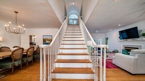 Eine Treppe mit weißen Geländern, die zu einer Zwischenebene führt.