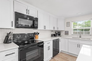 Enjoy cooking and entertaining in this well-equipped kitchen with ample counter space and essential utensils.
