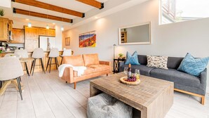 Uma sala de estar moderna com sofá, mesa de centro e área de refeições.