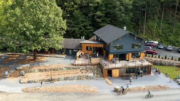 A lodge with a wooden deck, outdoor seating, and a bike rental area.