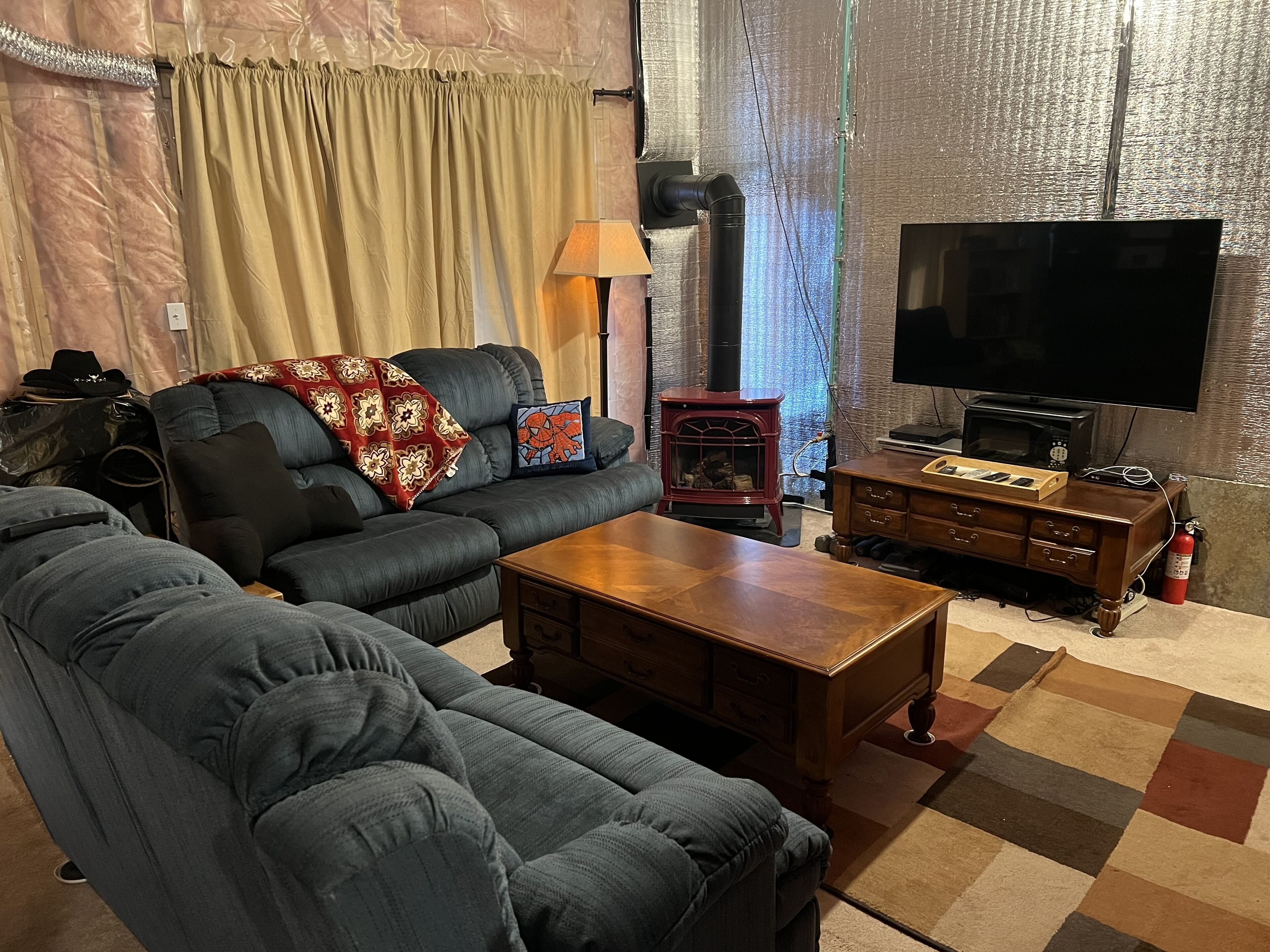 Een woonkamer met een hoekbank, een houten salontafel, een televisie en een open haard.
