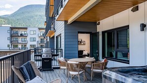 Una terraza con mobiliario exterior, una parrilla y un jacuzzi.