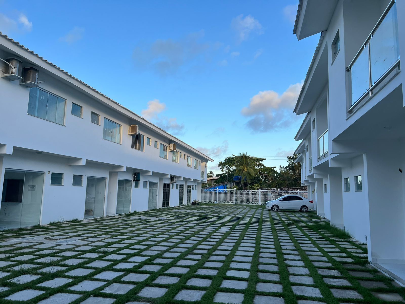 A courtyard with a paved walkway and buildings on either side.