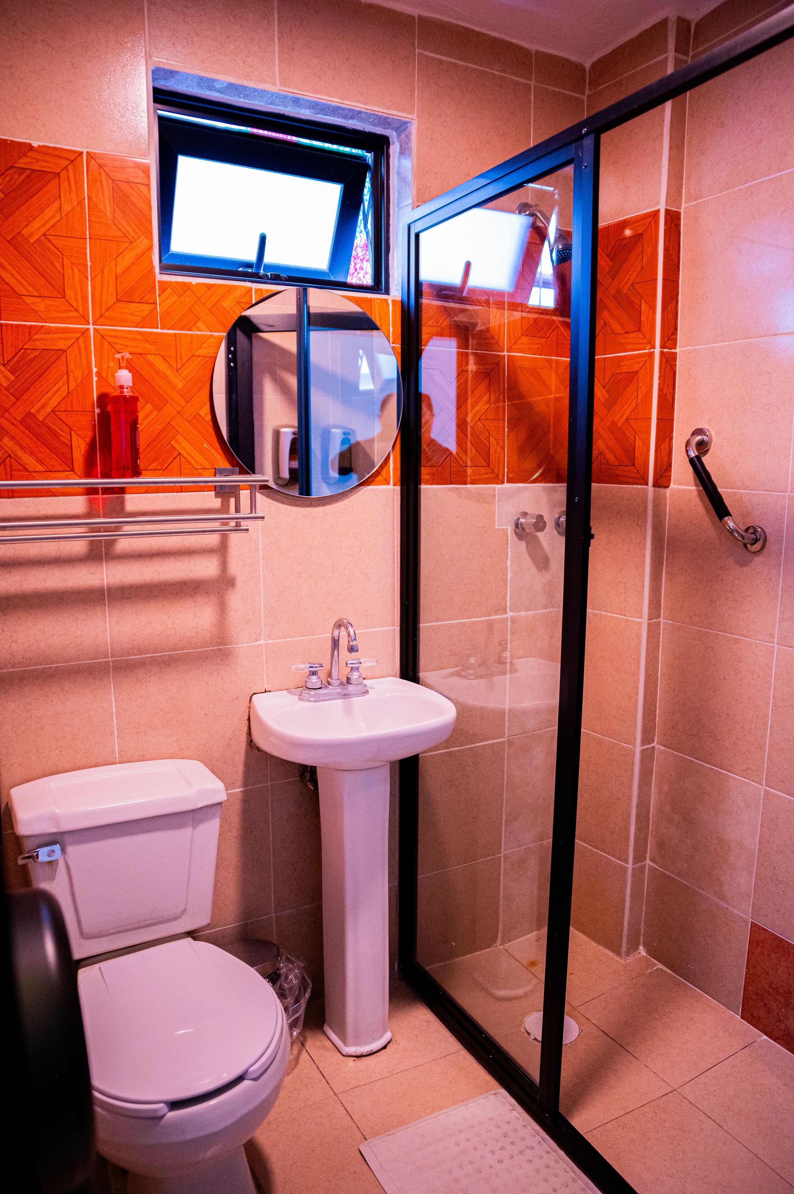 A bathroom with a toilet, sink, and shower.