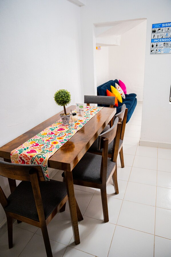 Uma sala de jantar com uma mesa de madeira, cadeiras e um jogo de mesa colorido.