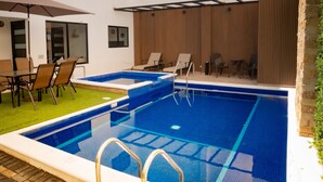 A swimming pool with a sun terrace, lounge chairs, and a dining area with a table and chairs. - HOTEL BUNGALOWS CASA BLANCA (Tenancingo)