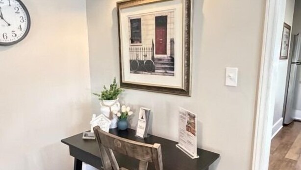 A dining area with a dark wooden table, a chair, a wall clock, a framed picture, and a wall-mounted light fixture. - Walking Distance to Casino (Danvilel)