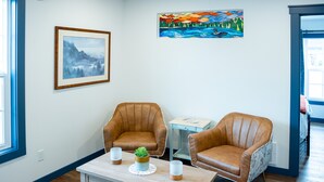 A room with two brown leather chairs, a wooden coffee table with a plant, and a framed picture on the wall. - Hyland Hotel (Palmer)
