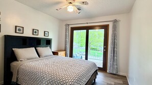 A bedroom with a bed, a ceiling fan, a nightstand, and a window with a view of the outside. - Extra clean home-free parking & Wi-Fi/self-check-in (Champaign)