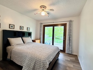 A bedroom with a bed, a ceiling fan, a nightstand, and a window with a view of the outside. - Extra clean home-free parking & Wi-Fi/self-check-in (Champaign)