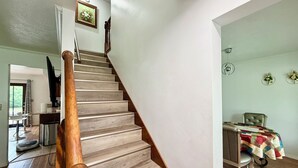 A staircase with wooden steps and a wooden handrail, leading to a room with a desk and a chair. - Extra clean home-free parking & Wi-Fi/self-check-in (Champaign)