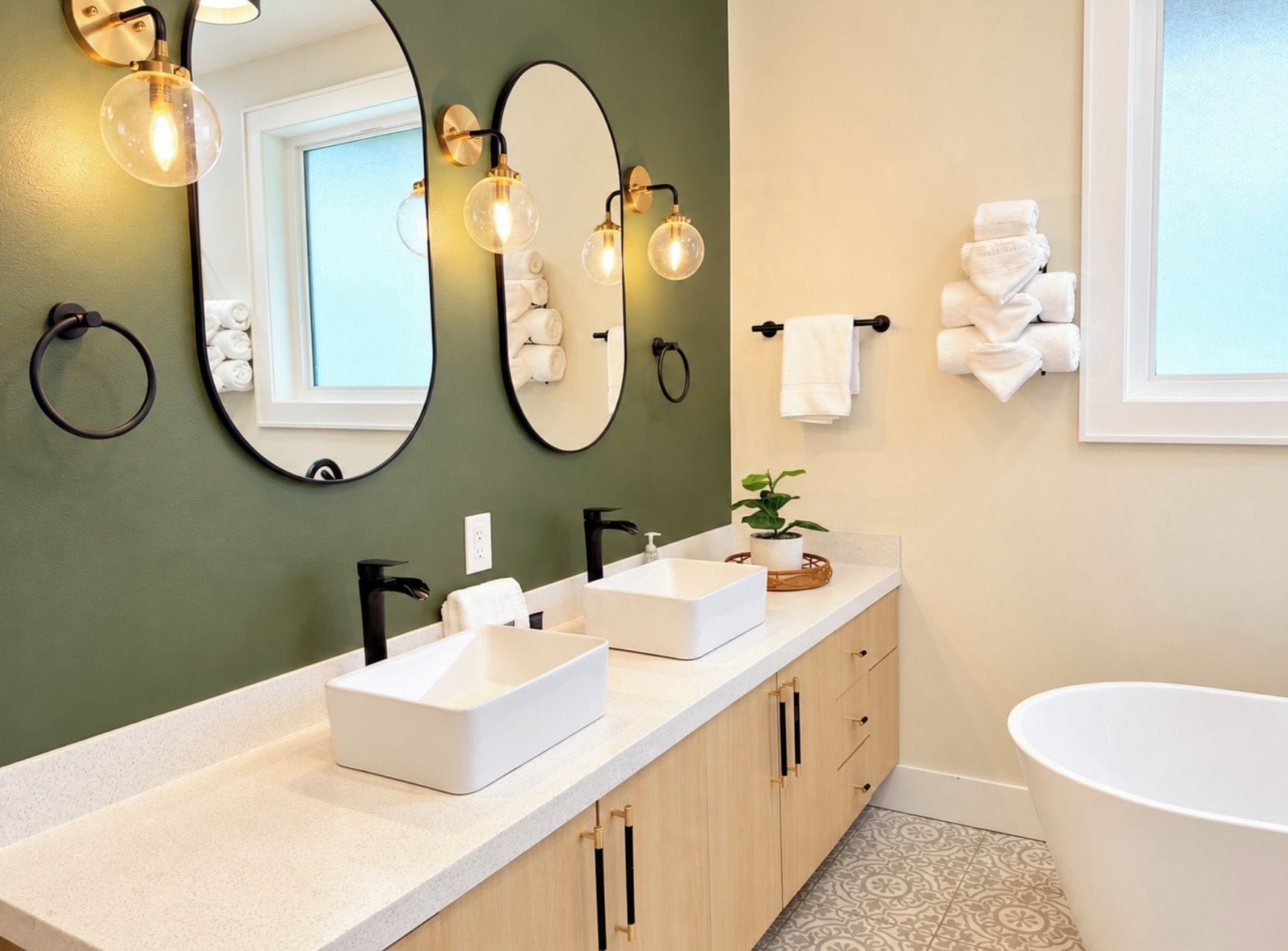 Une salle de bain moderne avec deux lavabos, un grand miroir et une baignoire.