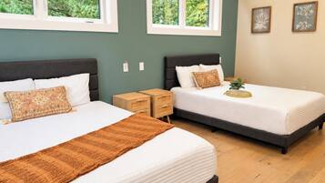 A bedroom with two beds, a window, and a nightstand.