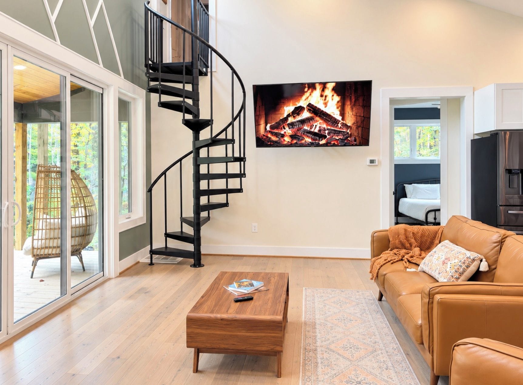 A modern living room with a spiral staircase, a fireplace, a sofa, and a coffee table.
