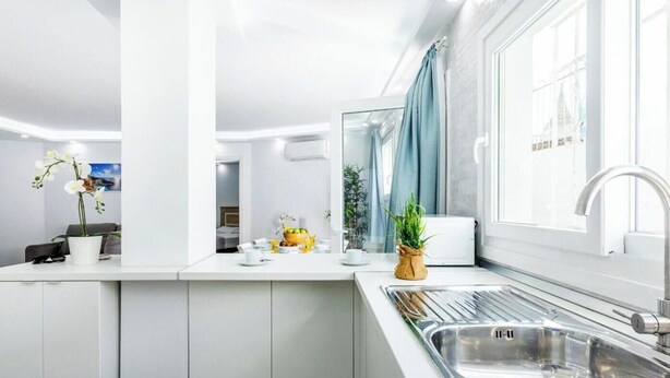 Een moderne keuken met een inbouwgootsteen, een ontbijtbalk en een uitzicht op de stad door grote ramen.