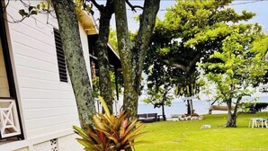 A garden with a variety of plants and rocks, a 'WELCOME' sign, and a white building in the background. - 2 bedroom Beach House at Bluefields Bay (Cave)