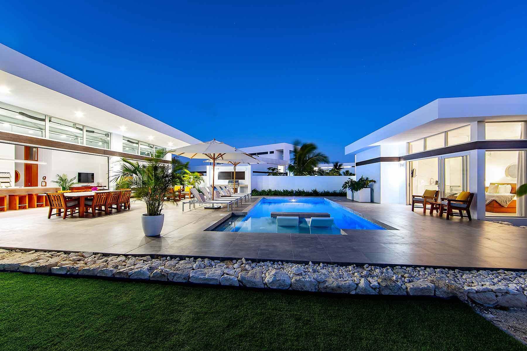 A modern outdoor pool area with a dining setup and lounge chairs.