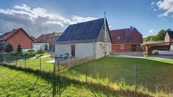 A residential area with houses, a fenced yard, and a solar panel on one house.