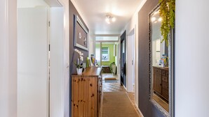 A hallway with a wooden cabinet, a mirror, and a door leading to another room. - Apartment 'Baumelt' with Private Terrace, Shared Garden and Wi-Fi (Hechingen)