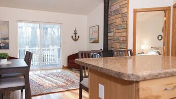 A kitchen with a granite countertop, wooden cabinets, and a stone accent wall.