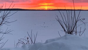 A snowy landscape with a sunset over a flat terrain. - Lazy Fox Lodge, Lake of the Woods
 (Baudette)