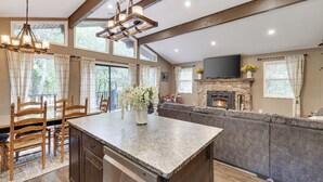 A spacious kitchen with a large island, wooden chairs, and a fireplace. - Peaceful Pocono Home Hot Tub minutes away from Kalahari, Camelback, Mt Airy (Long Pond)