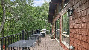 A wooden deck with outdoor furniture, a glass door, and a view of trees. - Peaceful Pocono Home Hot Tub minutes away from Kalahari, Camelback, Mt Airy (Long Pond)