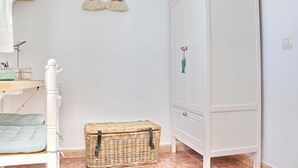 A child's room with a bed, a wardrobe, a small wicker basket, and a rainbow decoration on the wall. - Apartment Virtudes III (Conil de la Frontera)