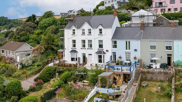A multi-story house with a garden and a staircase leading to the upper floor.