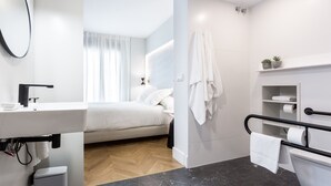 Une salle de bain moderne équipée de toilettes, d’un lavabo et d’un espace douche.