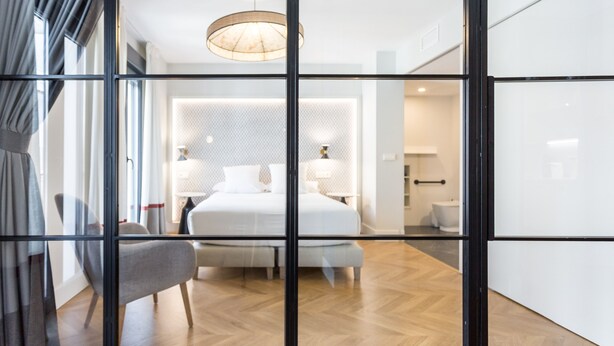 Une chambre d’hôtel moderne, dotée d’un grand lit, d’une chaise et d’un bureau.