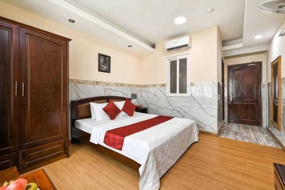 Une chambre d’hôtel avec un lit, une armoire et une porte.