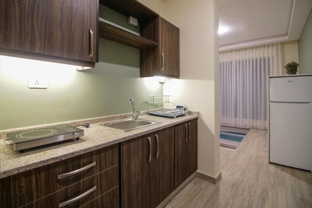 A modern kitchen with wooden cabinets, a built-in stove, and a white refrigerator.