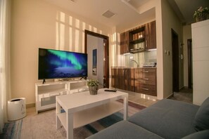 Departamento, 1 habitación | Área de sala de estar | Smart TV de 55 pulgadas con canales digitales y televisión