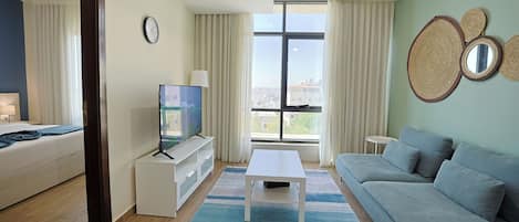 Departamento, 1 habitación | Área de sala de estar | Smart TV de 55 pulgadas con canales digitales y televisión