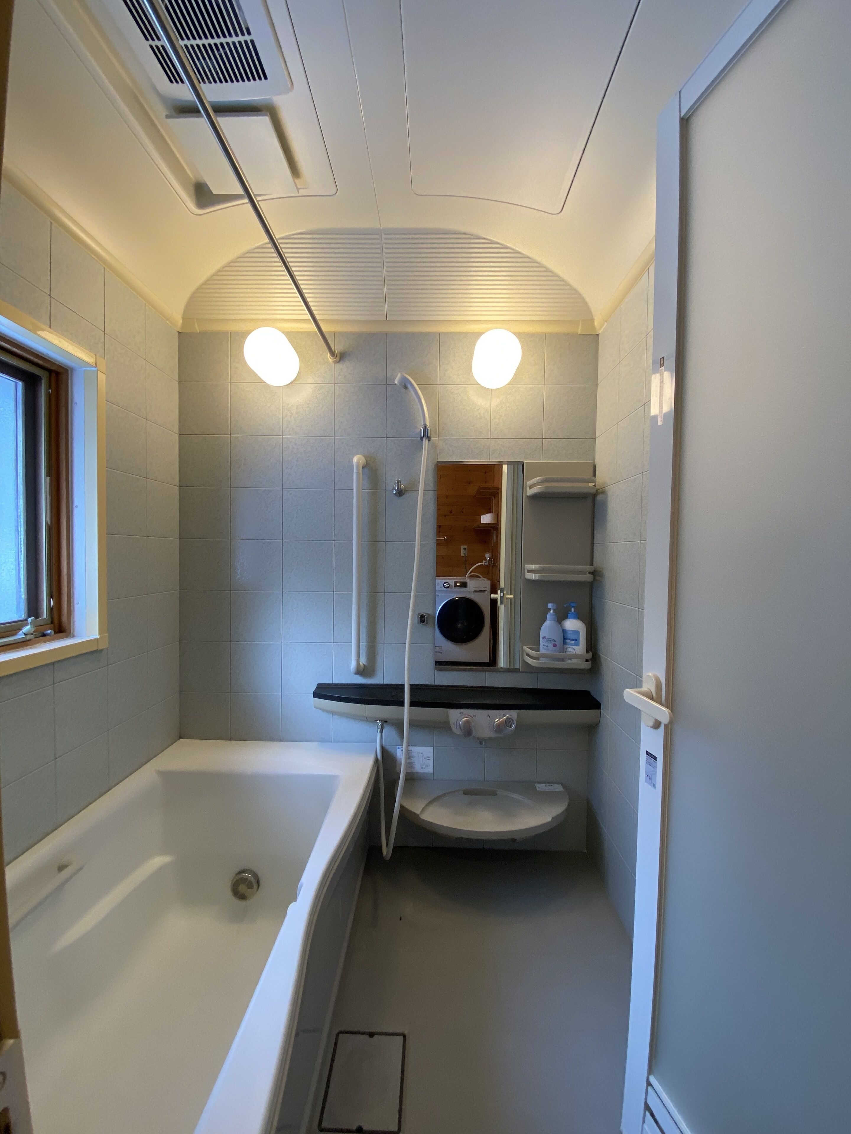 A compact bathroom with a bathtub, a toilet, and a shower.