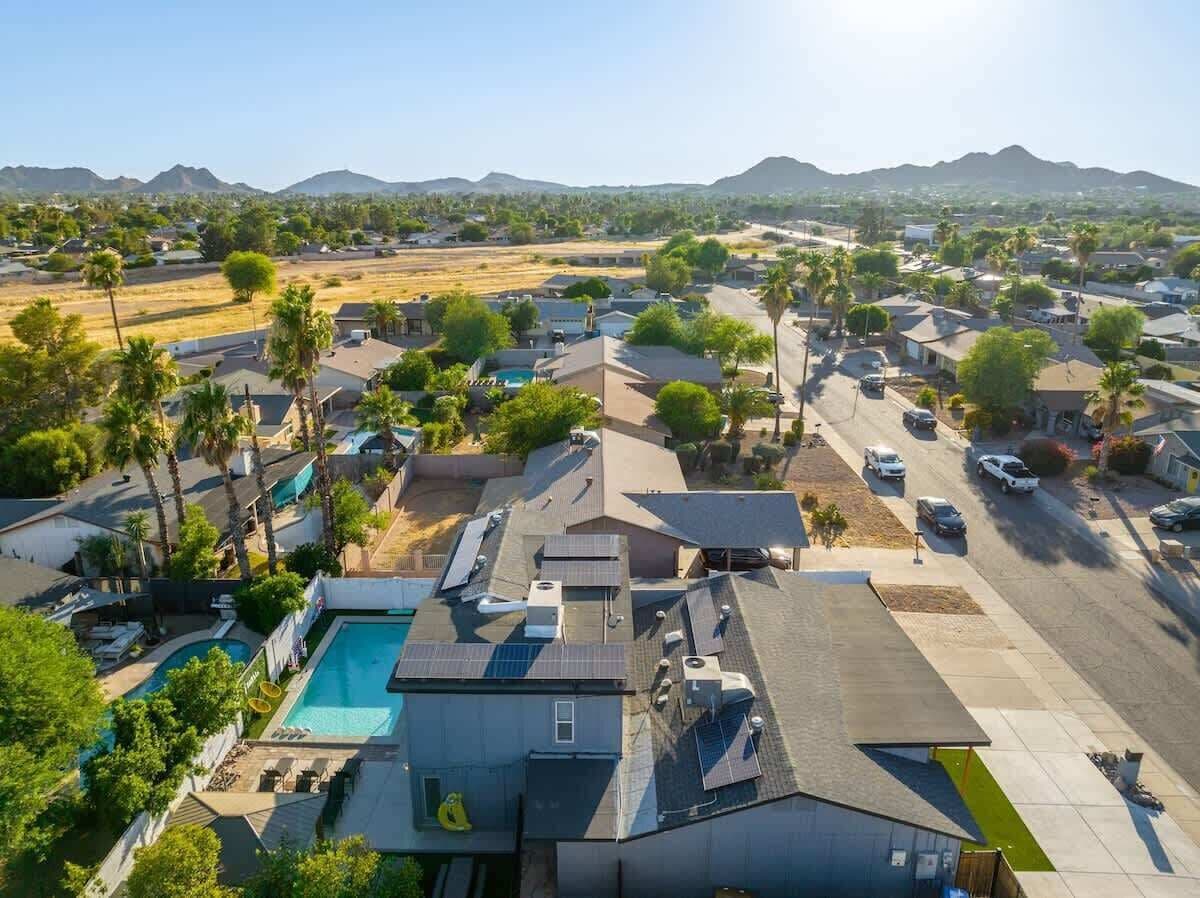 A residential area with houses, a swimming pool, and solar panels.