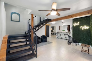 A modern interior with a staircase, a ceiling fan, and a green wall with a neon sign. - Extravagant Phoenix Retreat|Pool|Gazebo|HeatedPool (Phoenix)