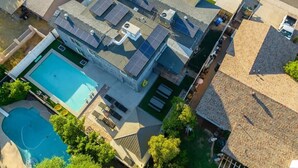 Un immeuble résidentiel doté d’une piscine, de panneaux solaires et d’un patio couvert.