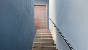 A staircase with wooden steps and a metal handrail, leading to a wooden door. - Hotel La Bikina (Tequila)